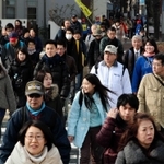 ２０年前からがらりと変わった街を歩く参加者ら＝神戸市中央区生田町３