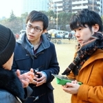 東遊園地でインタビューをする岡田さん（右）と広石さん＝１月１７日、神戸市中央区加納町６