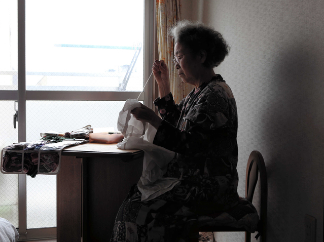 窓際の光を頼りに裁縫をする笠松美智子さん＝神戸市兵庫区（撮影・中西大二）