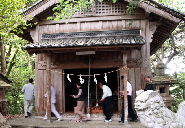 北但大震災が起きた５月２３日。犠牲者を悼み、神社の社殿の周囲を回る住民＝豊岡市田結、八坂神社