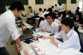 ＯＢ（左）のアドバイスを受けながら学ぶ民谷美友斗君（中央）ら１年生＝神戸市垂水区学が丘