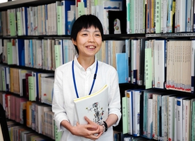 阪神・淡路大震災関連の資料に囲まれて働く岸本くるみさん＝神戸市中央区脇浜海岸通１、人と防災未来センター（撮影・三浦拓也）