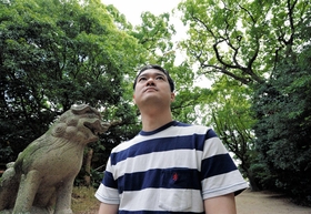 高木熊野神社の森を見上げる津高智博さん。震災前の記憶が思い浮かぶ＝西宮市高木東町（撮影・笠原次郎）