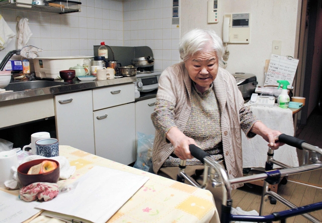 歩行器で生活する松山サヨノさん。転倒しないよう、ゆっくり進む＝神戸市中央区脇浜町３