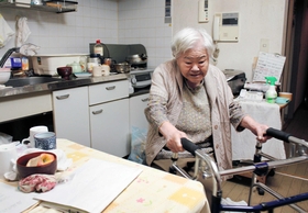 歩行器で生活する松山サヨノさん。転倒しないよう、ゆっくり進む＝神戸市中央区脇浜町３