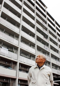 入居から半年。荒井東復興公営住宅を見上げる大橋公雄さん＝仙台市若林区荒井