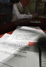 月千円返済の期間延長を告げる通知書。借金を返す時間は一向に減らない＝神戸市中央区（撮影・中西幸大）