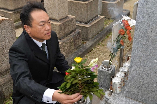 祖母ゆきゑさんが眠る墓に花を手向ける小林庸人さん＝西宮市馬場町２（撮影・風斗雅博）