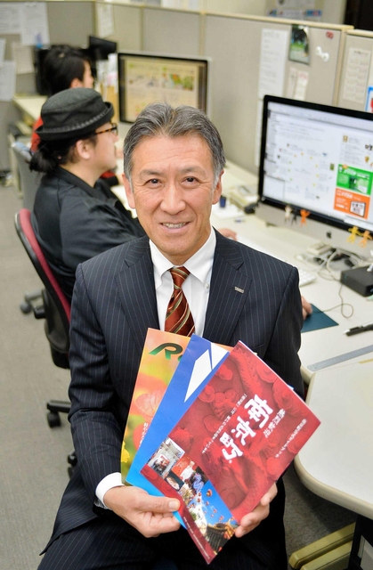 デザイン制作などを担当する若い社員らを前に、「どんな媒体でも、印刷業で培った感性を生かせる」と話す岸徹さん＝神戸市中央区橘通１、トライス（撮影・中西幸大）