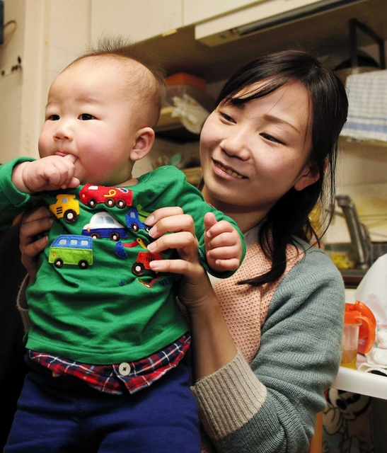 ７カ月の結ちゃんをあやす早川美幸さん＝神戸市長田区（撮影・三浦拓也）