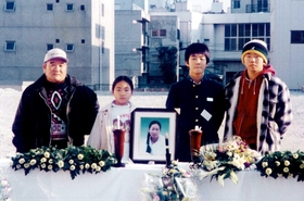 西市民病院で亡くなった長尾裕美子さんを悼む家族＝１９９７年１月１７日、神戸市長田区一番町、同病院本館跡地（提供）