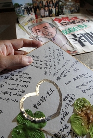 幸田修一さんが多くの人に慕われていたことがうかがえる寄せ書きや写真＝西宮市樋ノ口町１（撮影・峰大二郎）