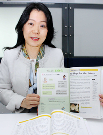 阪神・淡路大震災の記述がある英語教科書を手にする京都教育大の泉恵美子教授＝神戸市中央区、神戸新聞社　