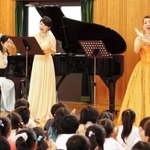 手拍子をしながらピアノの音色と歌声の美しいハーモニーを楽しむ児童ら＝糀台小学校