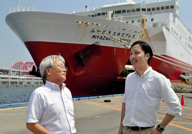 宮崎カーフェリーの船舶を前に、事業の計画などについて語らう岡田関西支店長（左）と川上悠介さん＝神戸三宮フェリーターミナル