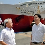 宮崎カーフェリーの船舶を前に、事業の計画などについて語らう岡田関西支店長（左）と川上悠介さん＝神戸三宮フェリーターミナル