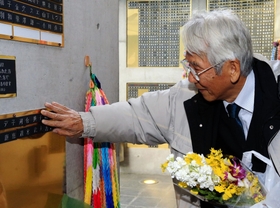 「慰霊と復興のモニュメント」に取り付けた母の銘板を指でなぞる河合次郎さん＝１９日午後、神戸市中央区加納町６（撮影・大森　武）