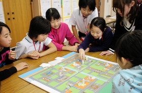 手作りの防災ゲームを小中学生に教える明石工業高等専門学校の生徒たち＝神戸市西区井吹台東町４