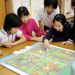 手作りの防災ゲームを小中学生に教える明石工業高等専門学校の生徒たち＝神戸市西区井吹台東町４
