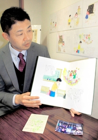 自身の体験をもとに書かれた絵本「おむすびの涙」を朗読する杉田二郎さん＝西宮市甲子園口１、ギャラリーわびすけ