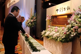 亡くなった児童・生徒らの名前が刻まれた銘板に献花する出席者＝神戸市中央区中山手通４