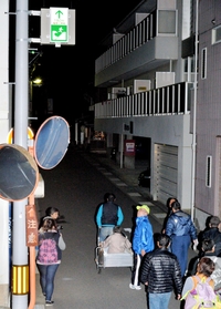 夜間の避難訓練で、誘導灯を目印に避難場所を目指す福良地区の住民＝２０１５年１１月２２日、南あわじ市福良乙（撮影・後藤亮平）