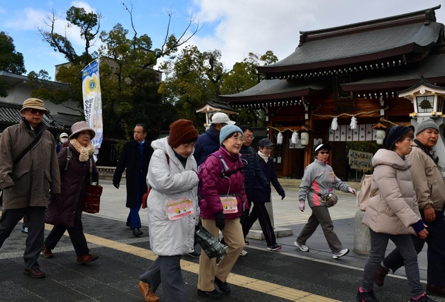 鳥居が倒れるなどの被害があった湊川神社周辺を歩く参加者ら＝神戸市中央区多聞通３（撮影・笠原次郎）
