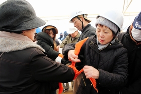 三角巾を使ったけがの応急手当訓練に当たる住民ら＝自由が丘中央公園
