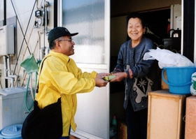 仮設住宅を訪問する岸岡さん（左）（岸岡さん提供）
