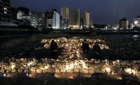 ライトアップで浮かび上がった石積みの「生」の字＝１６日夕、宝塚市の武庫川中州（撮影・三津山朋彦）
