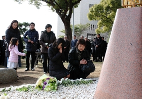 加藤りつこさんの隣で、慰霊碑に手を合わせる松田殊里さん（中央左）＝神戸大六甲台第一キャンパス