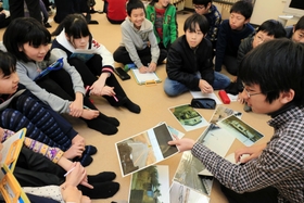 小学生に神戸や東北で起きた震災の被害などを伝える灘中学・高校の生徒＝神戸市東灘区向洋町中６、向洋小学校