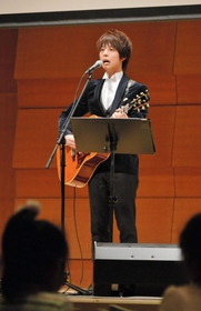 被災経験者の思いがこもった歌を熱唱するシンガーソングライターの石田裕之さん＝神戸市北区藤原台中町１、北神区民センター