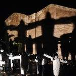 人影の十字架が浮かび上がった「神戸の壁」＝８日夜、北淡震災記念公園