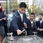 「希望の灯り」の火を持ち寄ったランタンに移す中学生ら＝９日午後、神戸市中央区、東遊園地