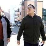 震災の語り部活動を始める柴田大輔さん（右）。語り部グループの崔敏夫さんと、今も更地が残る被災地を歩く＝神戸市須磨区千歳町１（撮影・小林良多）
