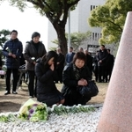 加藤りつこさんの隣で、慰霊碑に手を合わせる松田殊里さん（中央左）＝神戸大六甲台第一キャンパス