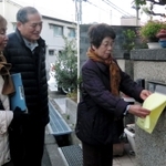 郵便受けにタオルを掛ける女性（右）と、見守る民生委員ら＝明石市太寺４
