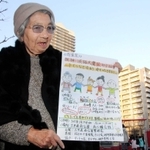 子どもたちが遊ぶ公園で慰霊祭のチラシを手にする斉木久美子さん＝六甲道南公園