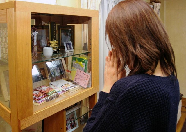 阪神・淡路大震災の復旧作業に従事後、悪性腹膜中皮腫で亡くなった島谷和則さんを思い、仏前で手を合わせる妻＝明石市内