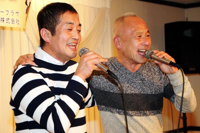 堀内圭三さん（右）と肩を組んで歌う木皿俊克さん（左）＝１６日午後、神戸市中央区三宮町１