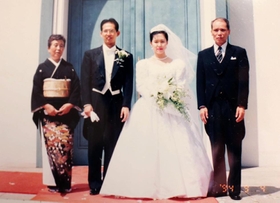 震災の４カ月前、神戸市内での結婚式で記念写真に収まる足立伸也さん、富子さん夫婦（中央）＝足立悦夫さん、朝子さん提供