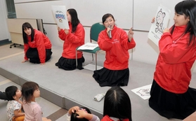 動物のイラストを示して、子どもたちに災害時の行動を教える青井陽さん（右から２人目）ら環境防災科の生徒たち＝神戸市中央区東川崎町１