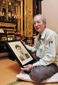 遺影を手に岡西久人さんの思い出を語る兄の明彦さん＝宍粟市一宮町