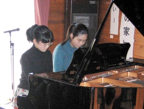 震災１０年のつどいで連弾する松本さん（右）と田中さん＝２００５年１月（浜風の家提供）
