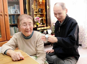 長男伸也さんの形見の時計を見ながら語り合う足立悦夫さん、朝子さん＝豊岡市塩津町