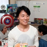 移転したばかりの事務所で、商品を手に笑顔を見せる鈴木佑一さん＝大阪市西淀川区（撮影・後藤亮平）
