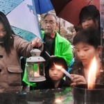 「１・１７希望の灯り」から火を移す子どもたち＝８日午後、神戸市中央区加納町６（撮影・吉田敦史）