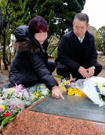 阪神・淡路大震災の慰霊碑に刻まれた長男の名前をなぞる母の栄子さん（左）と父幸夫さん＝神戸市灘区六甲台町