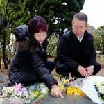 阪神・淡路大震災の慰霊碑に刻まれた長男の名前をなぞる母の栄子さん（左）と父幸夫さん＝神戸市灘区六甲台町